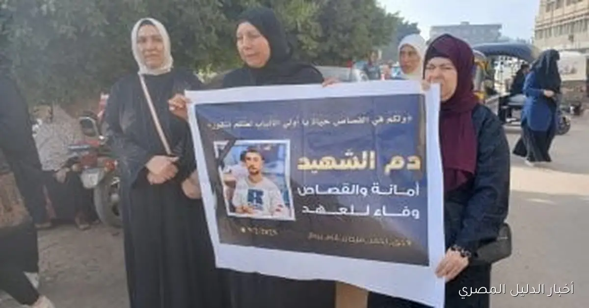 أسرة شاب من المحلة ترفع صورته قبل بدء الجلسة الثانية لمحاكمة المتهم بقتله